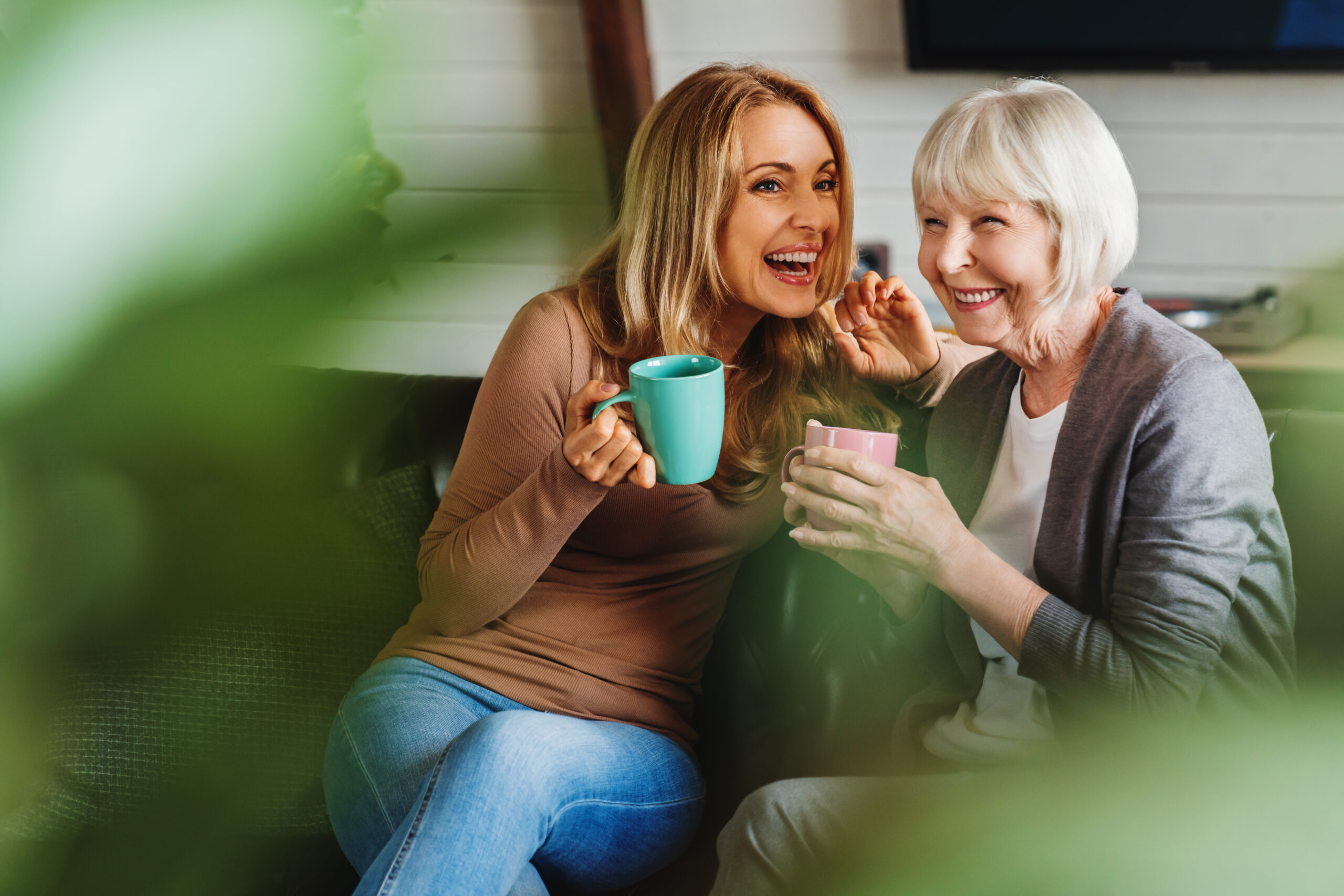 mom and daughter having coffe together and smiling